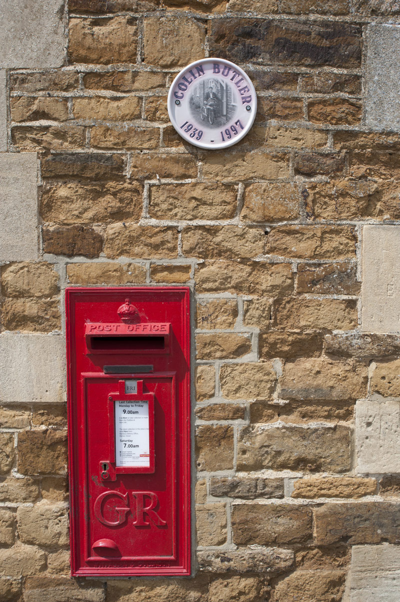 Red village postbox embedded in a wall